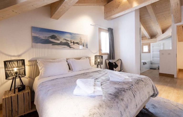 Slaapkamer met tweepersoonsbed en uitzicht op de bergen, appartement Genepi