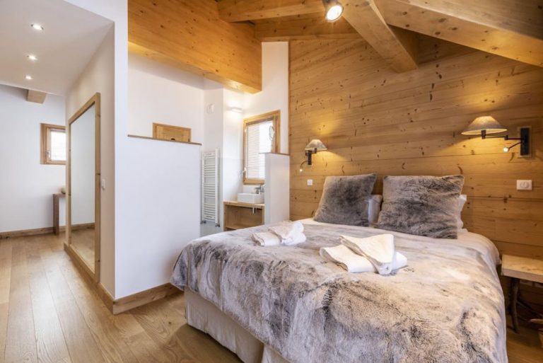 Slaapkamer met tweepersoonsbed en bontdeken, appartement Rose des Alpes